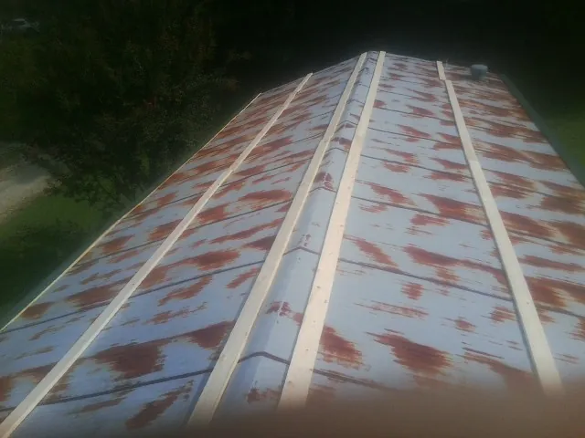 Rusted metal roof panels with new wood purlins before replacement — Storm Damage Roof Repair in Argyle by Roofing Brothers
